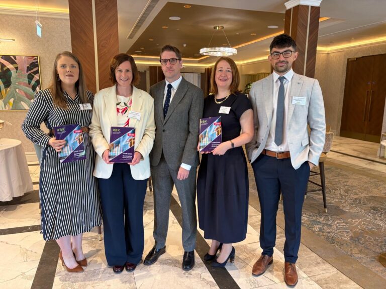 Our CU Seminar Speaker Lineup holding the RBK Credit Union Benchmarking Report Booklet
